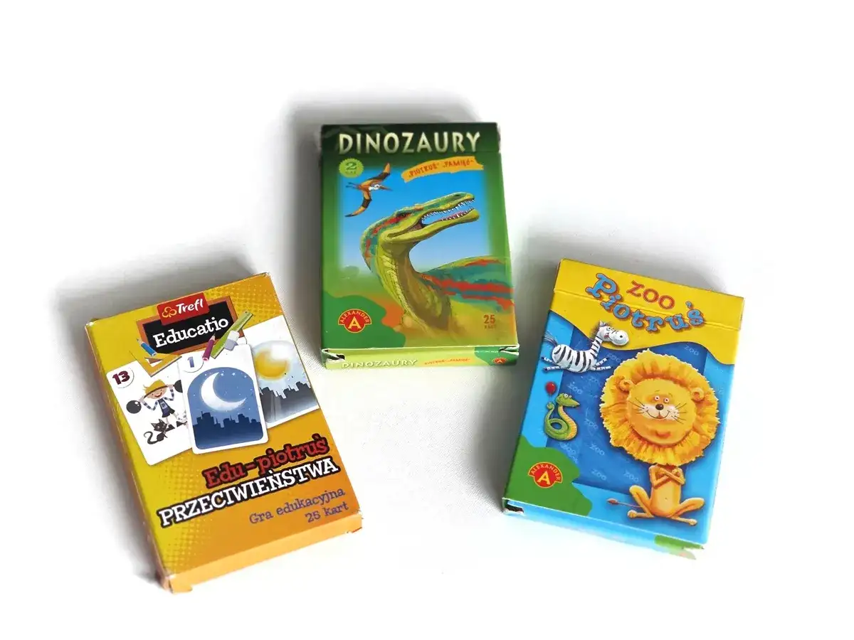 Trzy pudełka gier karcianych: "Dinozaury", "Zoo Piotruś" i "Edu-piotruś Przeciwieństwa".