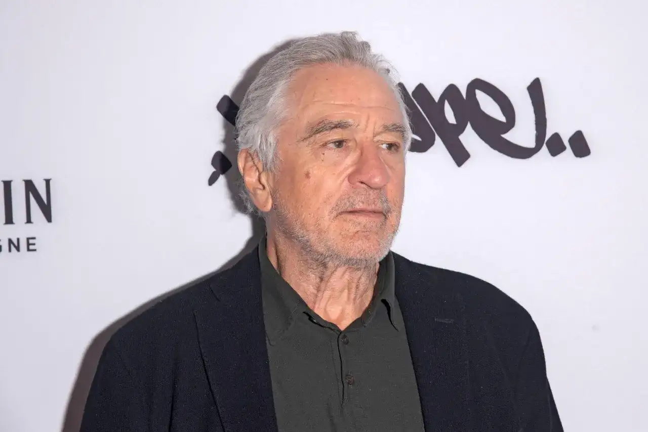 Robert De Niro, ikona kina, w czarnym swetrze i marynarce. Jego filmy to klasyka gatunku.