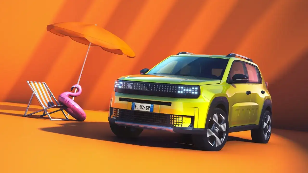 Nowy Fiat Panda w jaskrawym kolorze, gotowy na wakacje. Obok leżak, parasol i dmuchany flaming.
