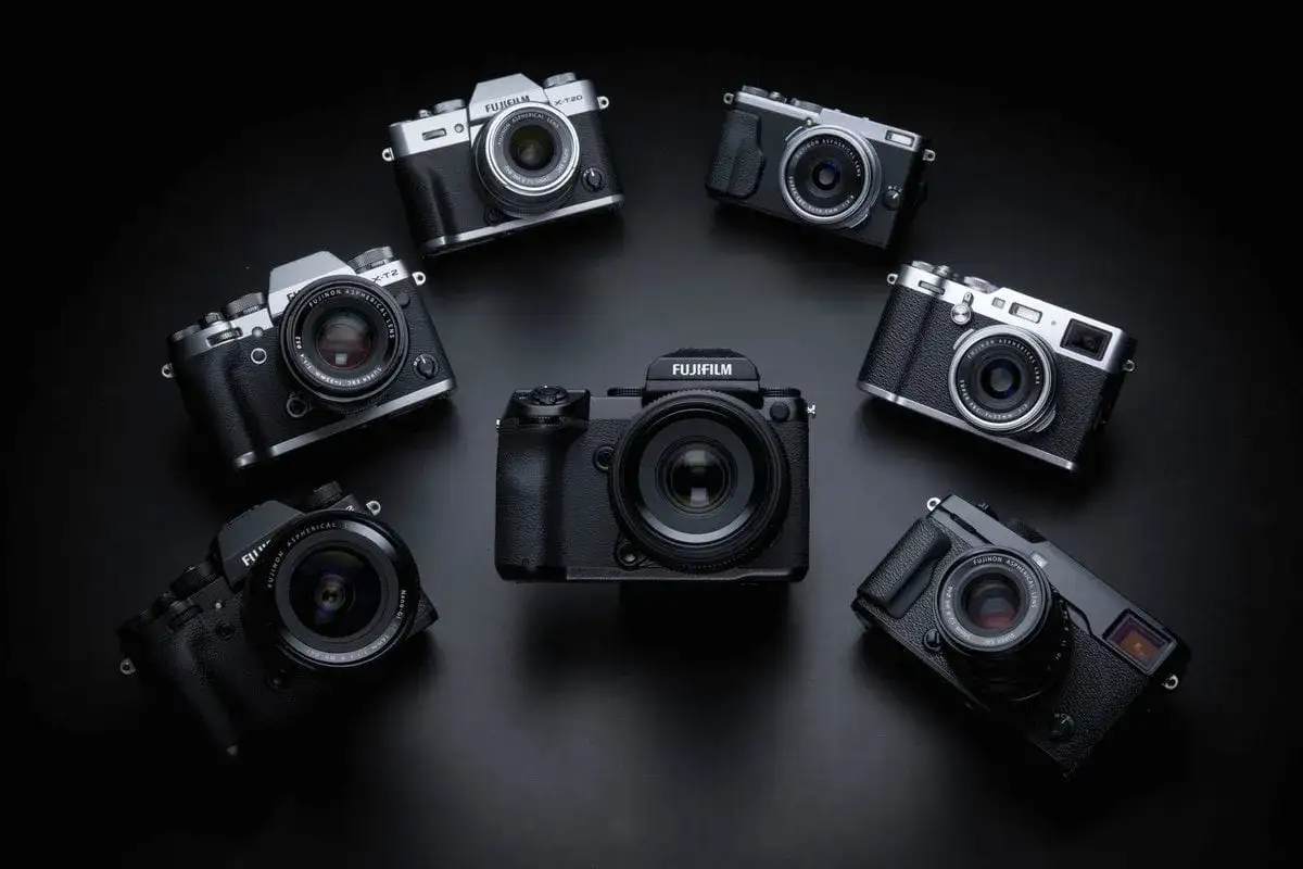 Kolekcja aparatów Fujifilm ułożona w okrąg. W centrum duży, czarny korpus, a wokół niego mniejsze modele, w tym X-T20. Każdy aparat to potencjalna pełna klatka możliwości.