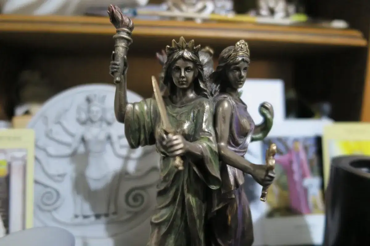 Figurka Hekate z pochodnią i mieczem, symbolizująca jej moc nad magią i przejściami.
