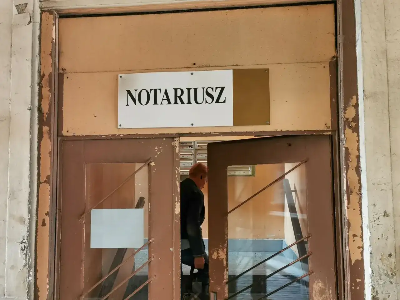 Mężczyzna wchodzi do biura notariusza, gdzie może sporządzić testament.