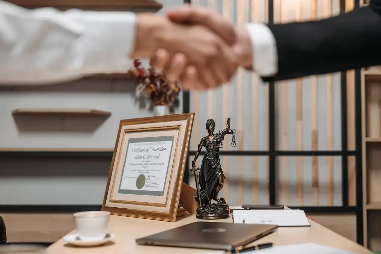 Uścisk dłoni prawników, certyfikat ukończenia i Statua Temidy. Dowiedz się, jak szybko się rozwieść, szukając profesjonalnej pomocy.
