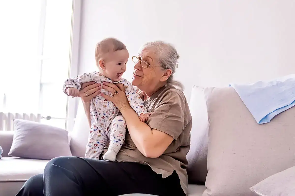 Babcia tuli niemowlę w piżamce z autkami. Czas spędzony w babciowych warunkach to czysta radość.