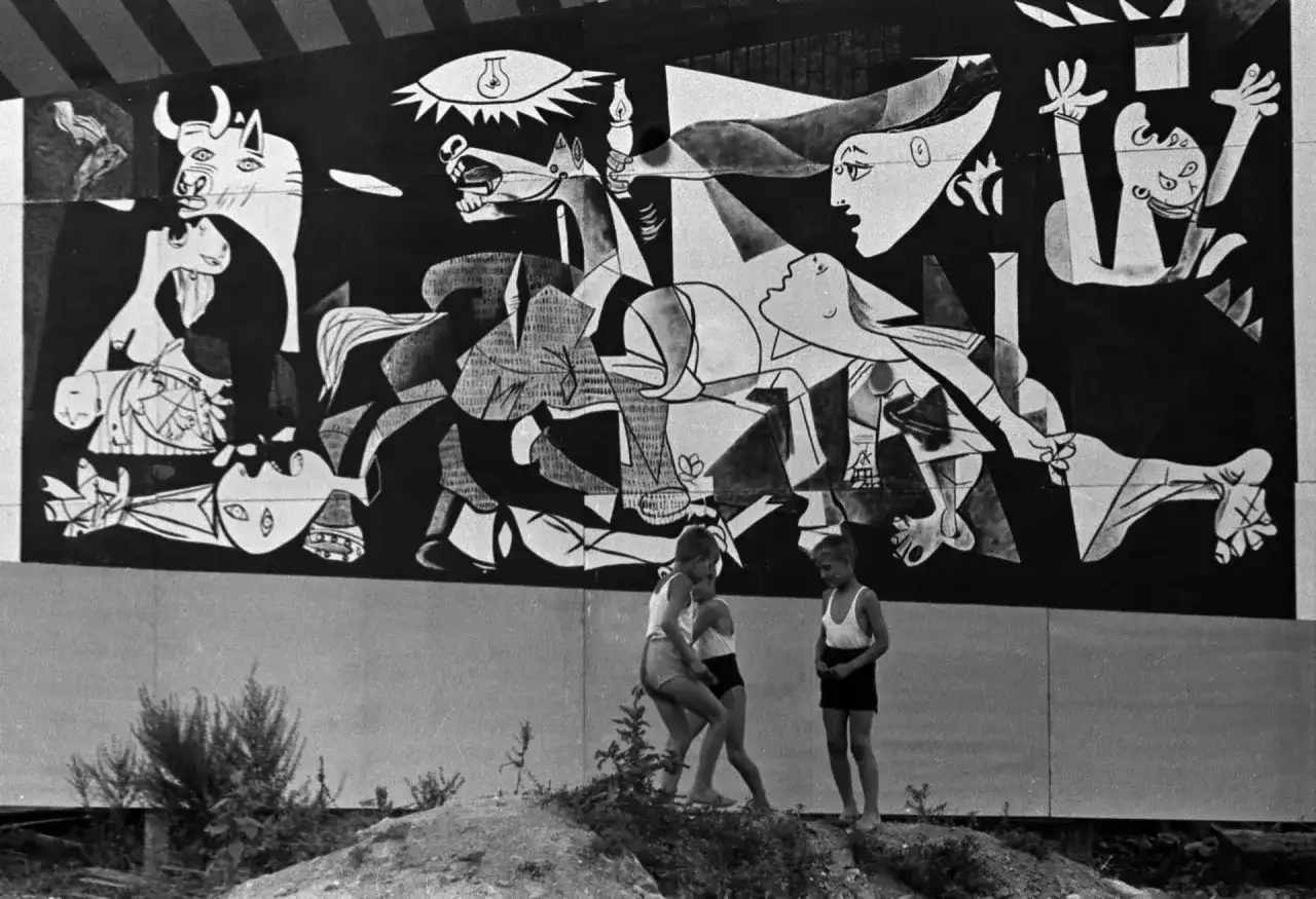 Dzieci bawią się przed monumentalnym obrazem Guernica.