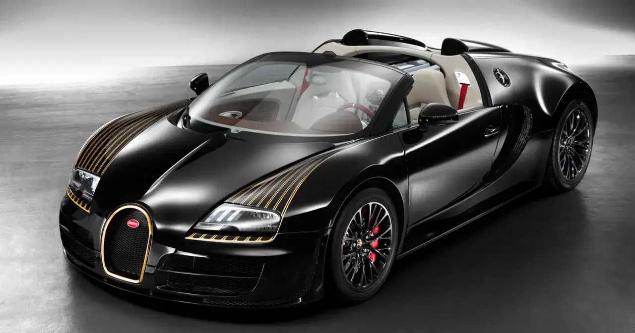 Czarny Bugatti Veyron z złotymi pasami na masce i złotą obwódką grilla. Kabriolet z jasnym wnętrzem.