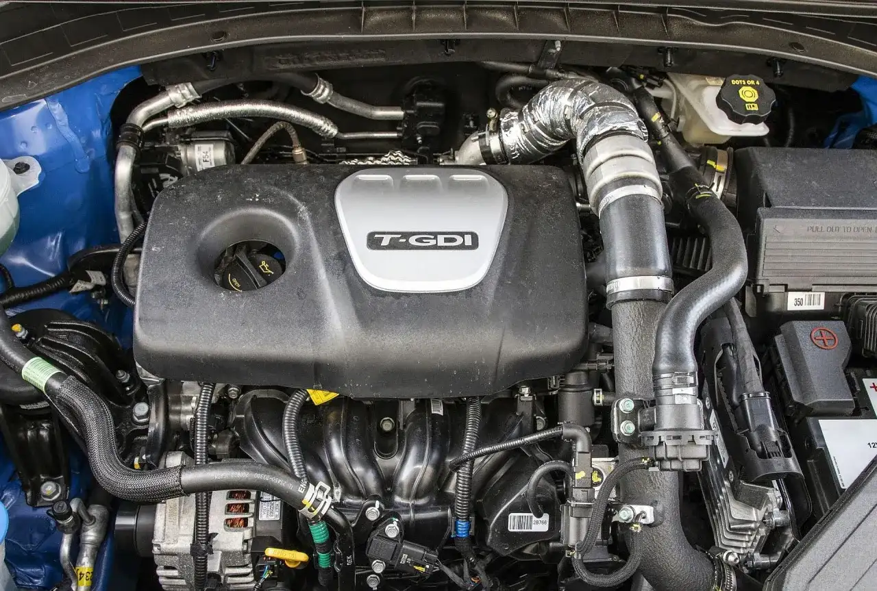 Silnik Kia Sportage 1.6 T-GDI z widocznym turbodoładowaniem i elementami układu dolotowego.