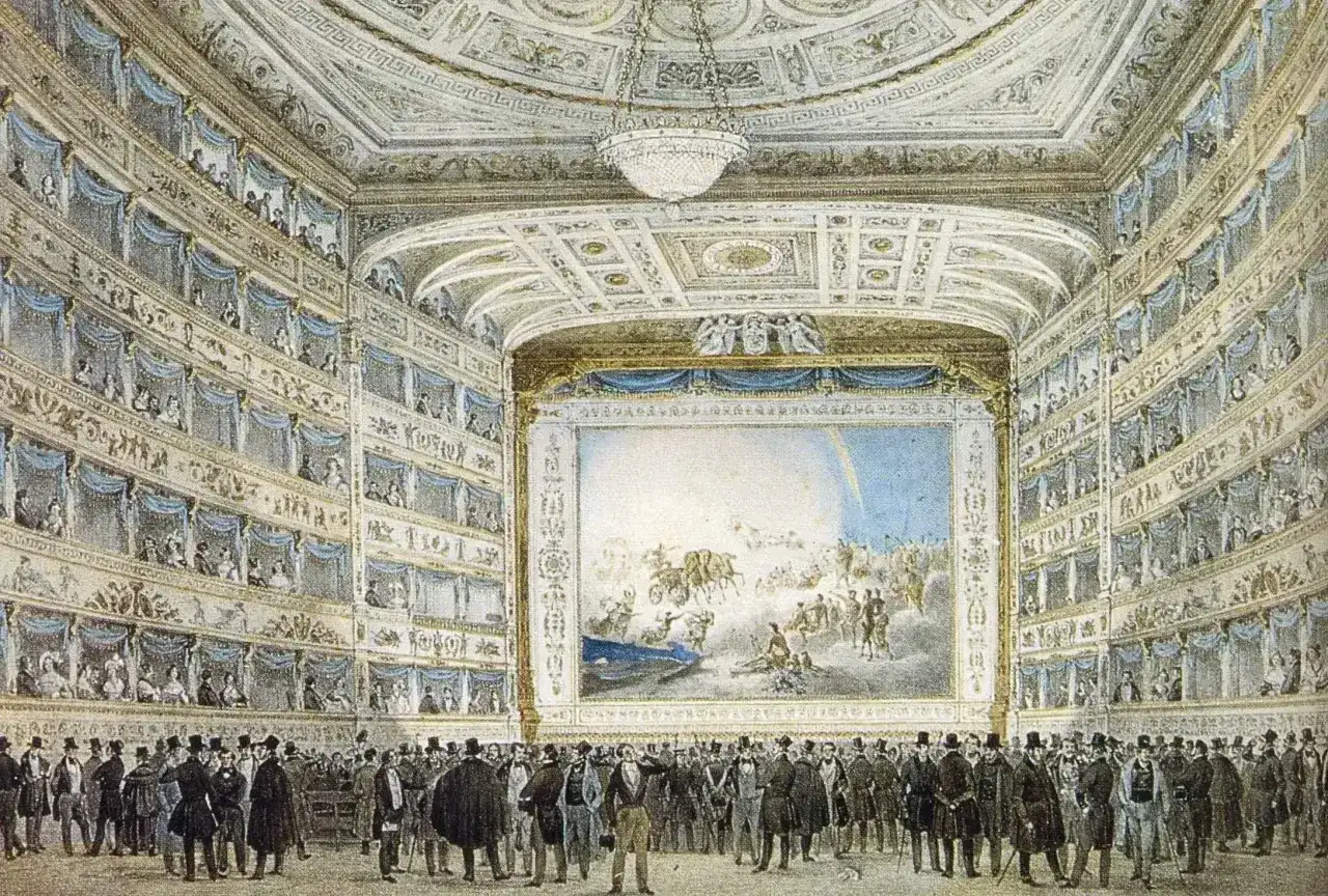 Widownia teatru z lożami pełnymi widzów, scena z malowidłem i tłum elegancko ubranych panów na parterze. Idealne miejsce na opery Verdiego.