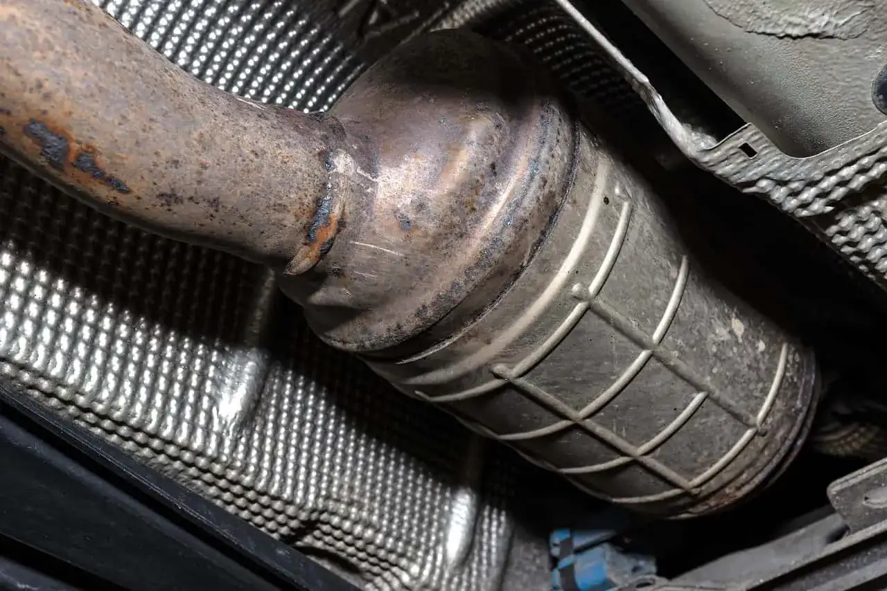 Zardzewiały element układu wydechowego, prawdopodobnie filtr DPF. Sprawdź czyszczenie DPF cena, by przywrócić sprawność.