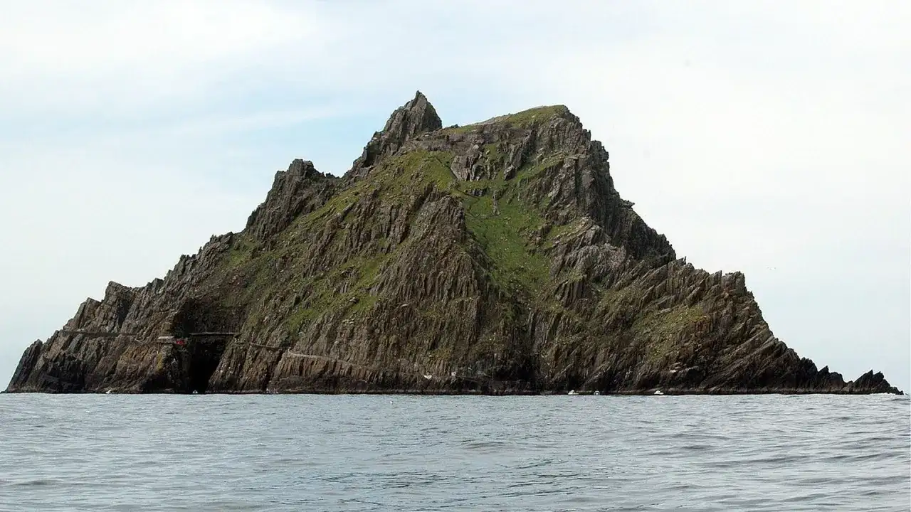 Skellig Michael, zielona, skalista wyspa na oceanie. Planując jak zorganizować logistykę trasy na wyspę Skellig Michael, pamiętaj o trudnym dostępie i zmiennej pogodzie.