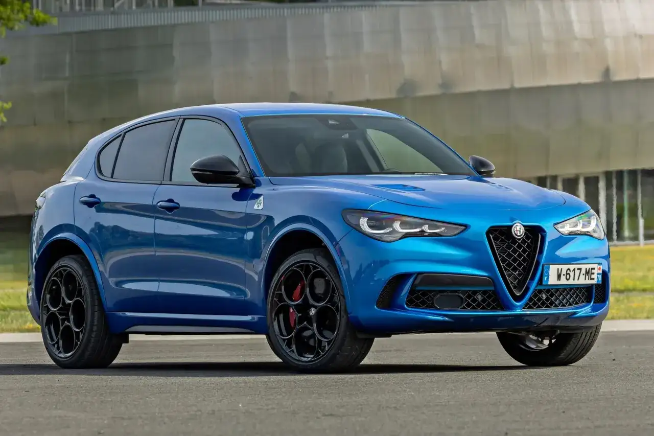 Niebieskie Alfa Romeo Stelvio z czarnymi felgami i czerwonymi zaciskami hamulcowymi. Sprawdź aktualną alfa romeo stelvio cena.