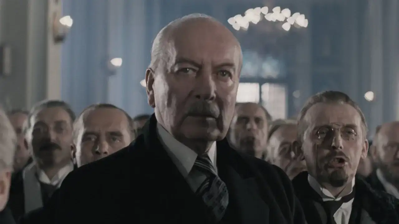Starszy mężczyzna z wąsami i grupą ludzi w tle. Czy to scena z filmu, która ukazuje największe błędy historyczne w polskich filmach, o których milczą twórcy?