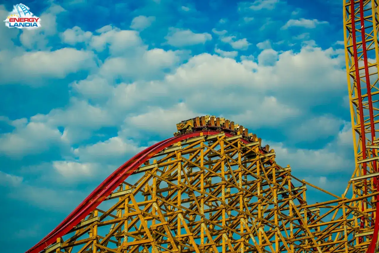 Zadra rollercoaster w Energylandii, drewniana konstrukcja i wagoniki na szczycie, gotowe do zjazdu.