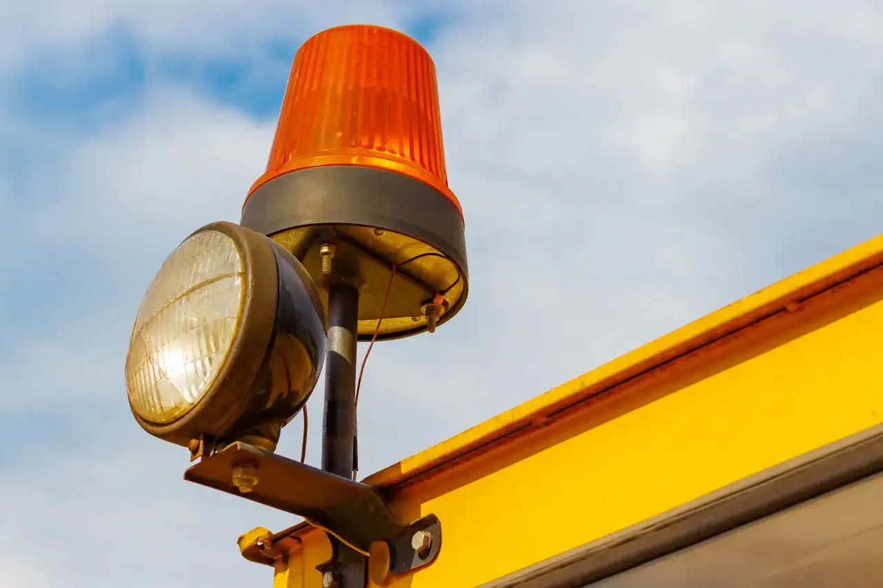 Un gyrophare orange et un phare sont fixés sur une structure jaune. Le schéma électrique de branchement gyrophare est visible.