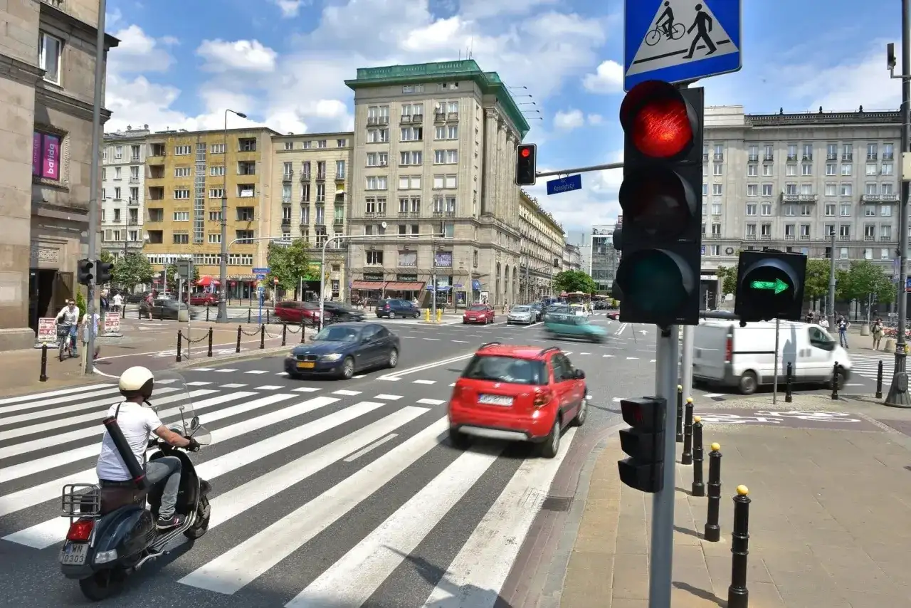 Sygnalizator S2 z czerwonym światłem dla samochodów i zieloną strzałką dla skręcających w prawo. Ruchliwe skrzyżowanie w mieście.