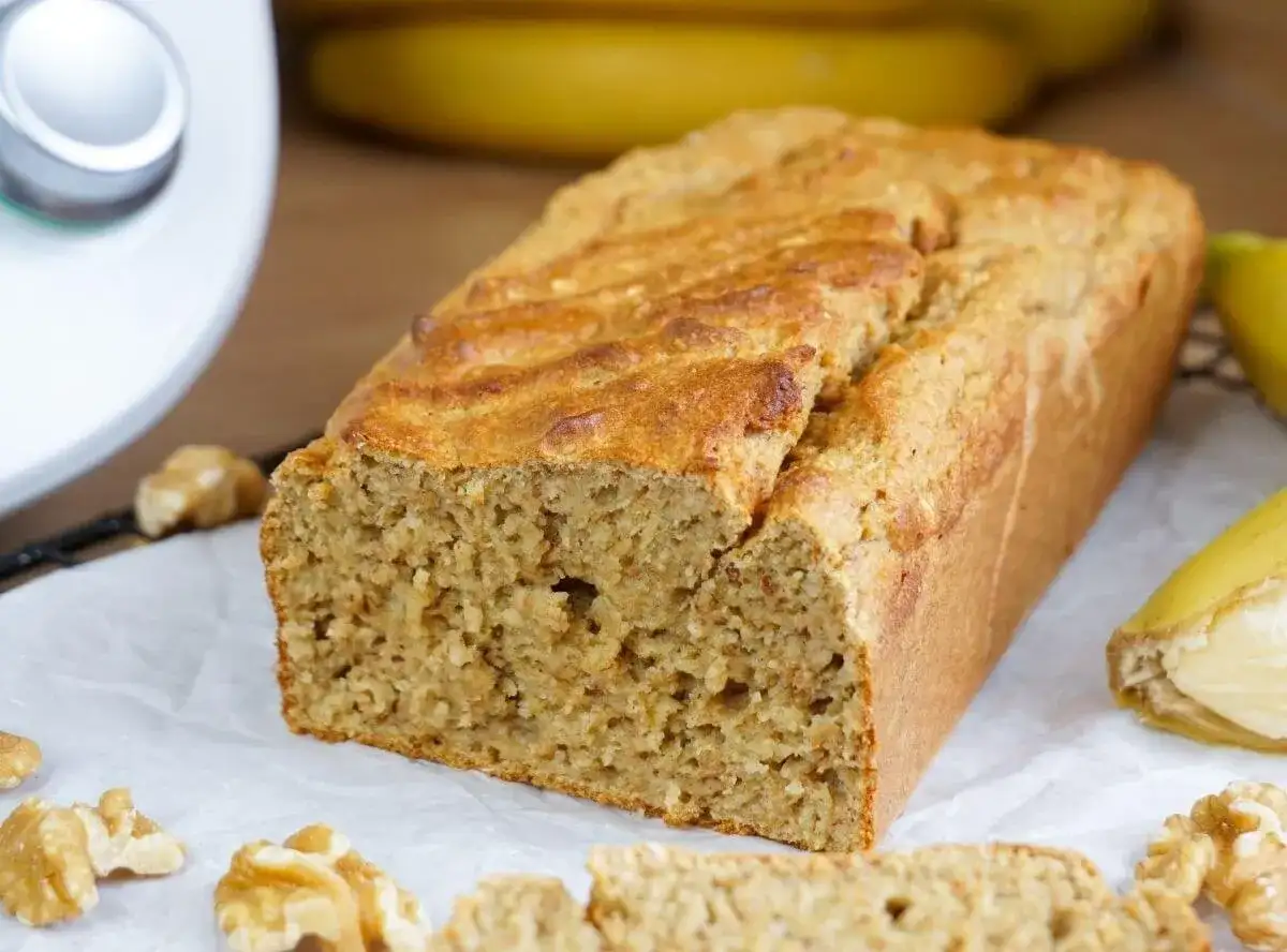 Saftiges Bananenbrot, frisch gebacken mit dem Thermomix. Nüsse und Bananen garnieren das köstliche Gebäck.