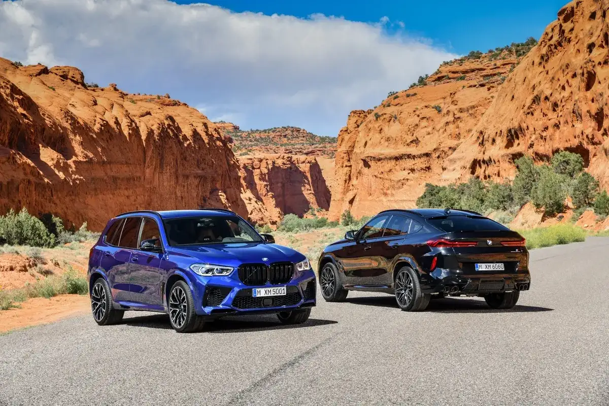 Dwa BMW X5M i X6M w malowniczym kanionie. Jeden niebieski, drugi czarny, gotowe na przygodę.