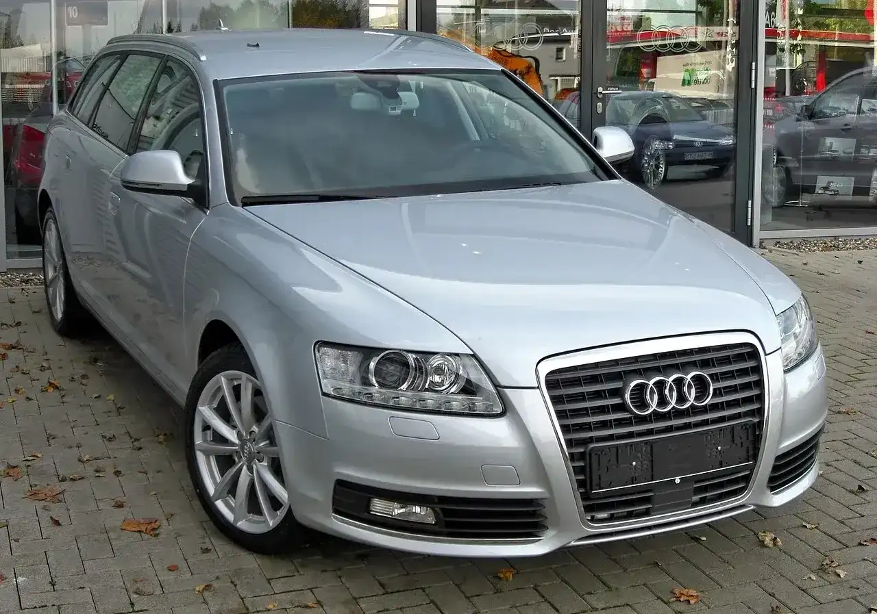 Srebrne Audi A6 C6 2.7 TDI Avant zaparkowane przed salonem.