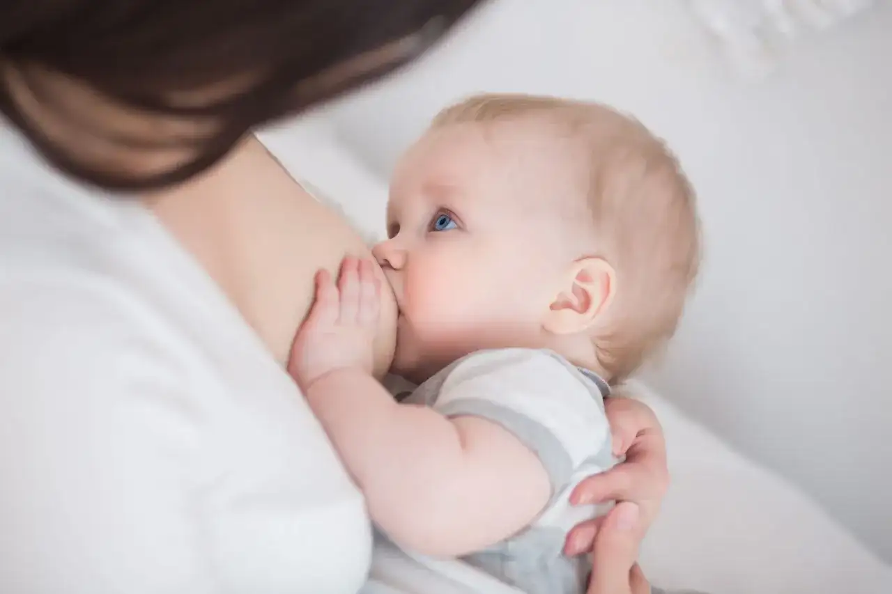 Niemowlę z niebieskimi oczami karmione piersią. Czas trwania nawalu laktacyjnego jest indywidualny.