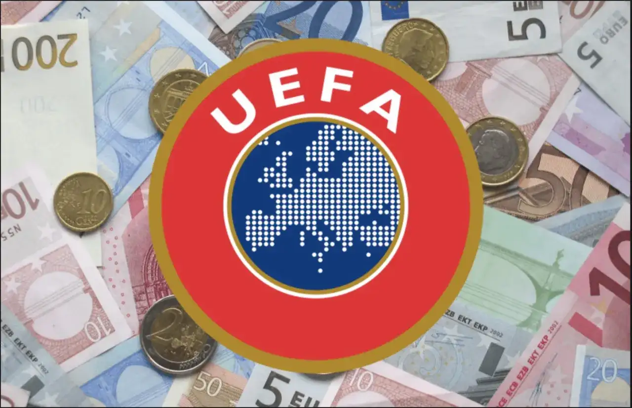 Logo UEFA na tle banknotów i monet euro. Symbolizuje finansowe fair play w europejskiej piłce nożnej.
