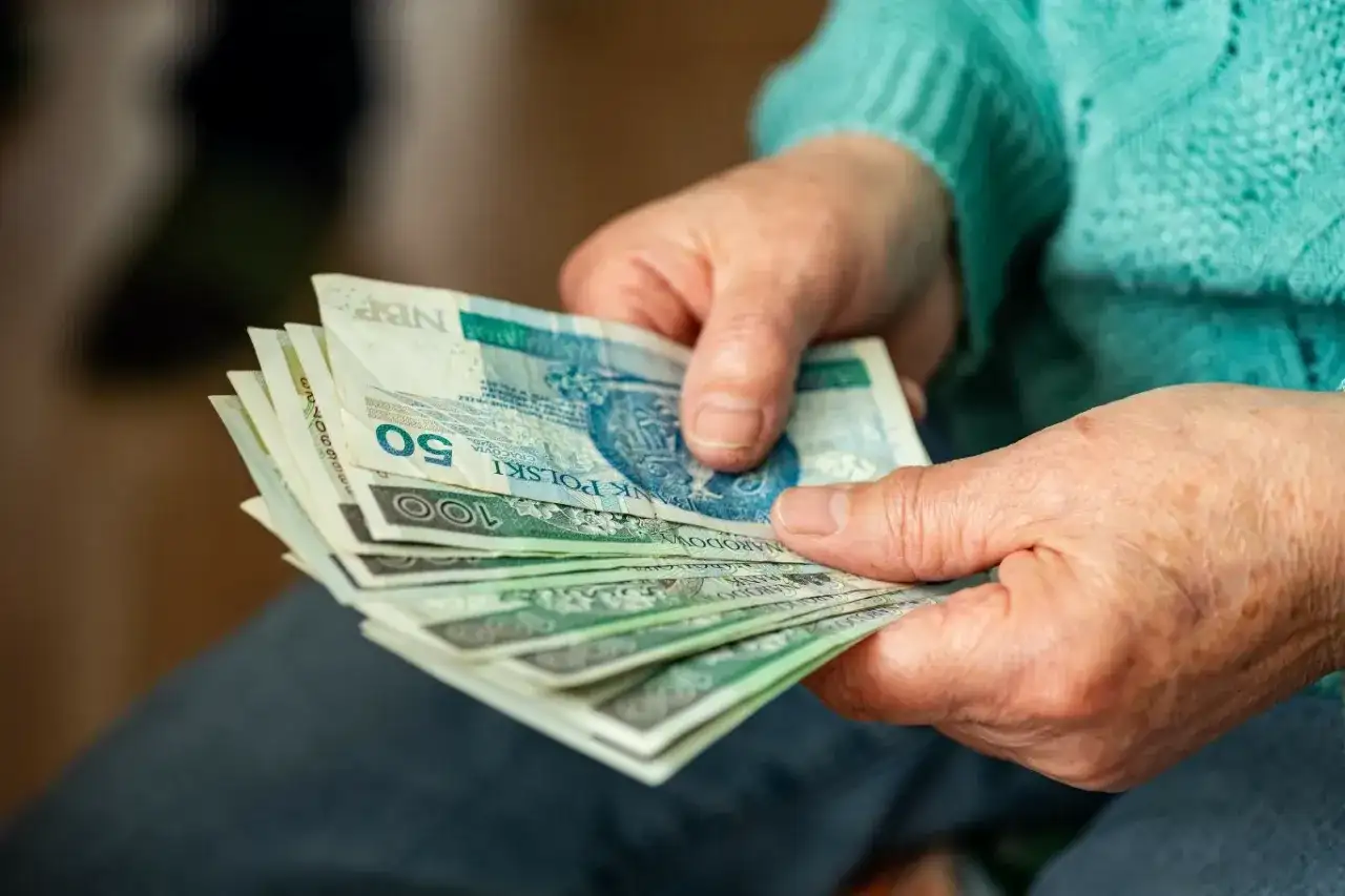 Dłonie liczą banknoty. Czy to dodatek do emerytury za warunki szkodliwe?