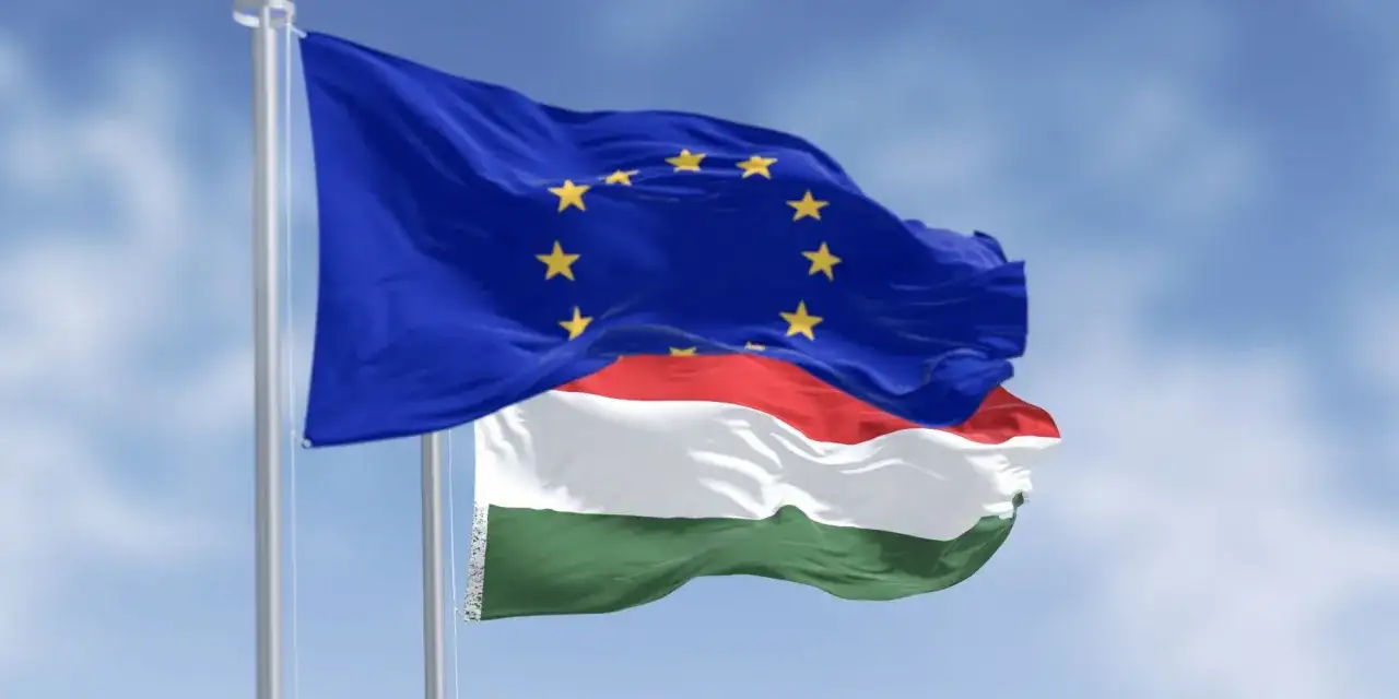 Flaga UE i Węgier powiewają na wietrze. Czy na Węgrzech można płacić euro? Oficjalnie nie, ale Unia Europejska to symbol wspólnoty.