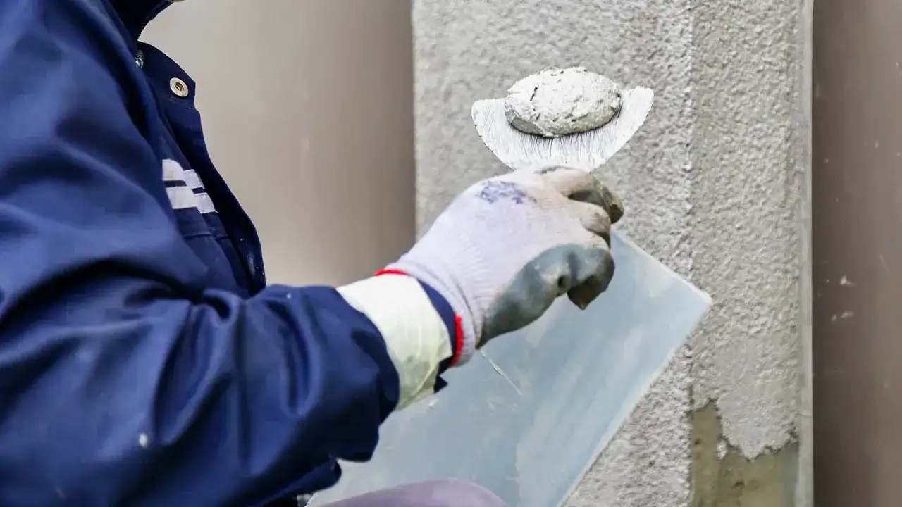 Pracownik nakłada tynk silikonowy na ścianę. Sprawdź atrakcyjną cenę za m2 robocizny.
