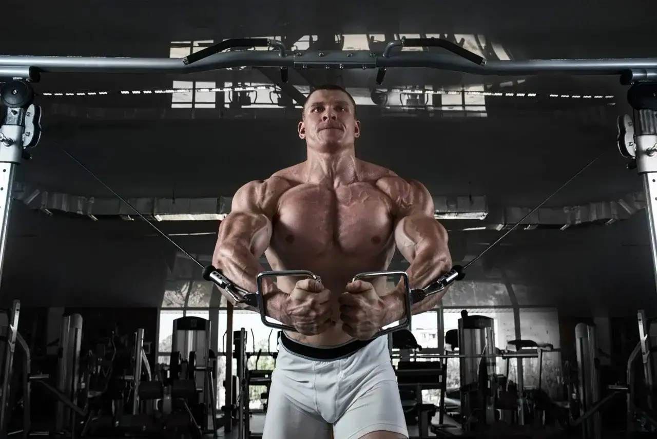 Mięśniowiec wykonuje ćwiczenie na klatkę piersiową na maszynie typu butterfly, co buduje mięśnie.