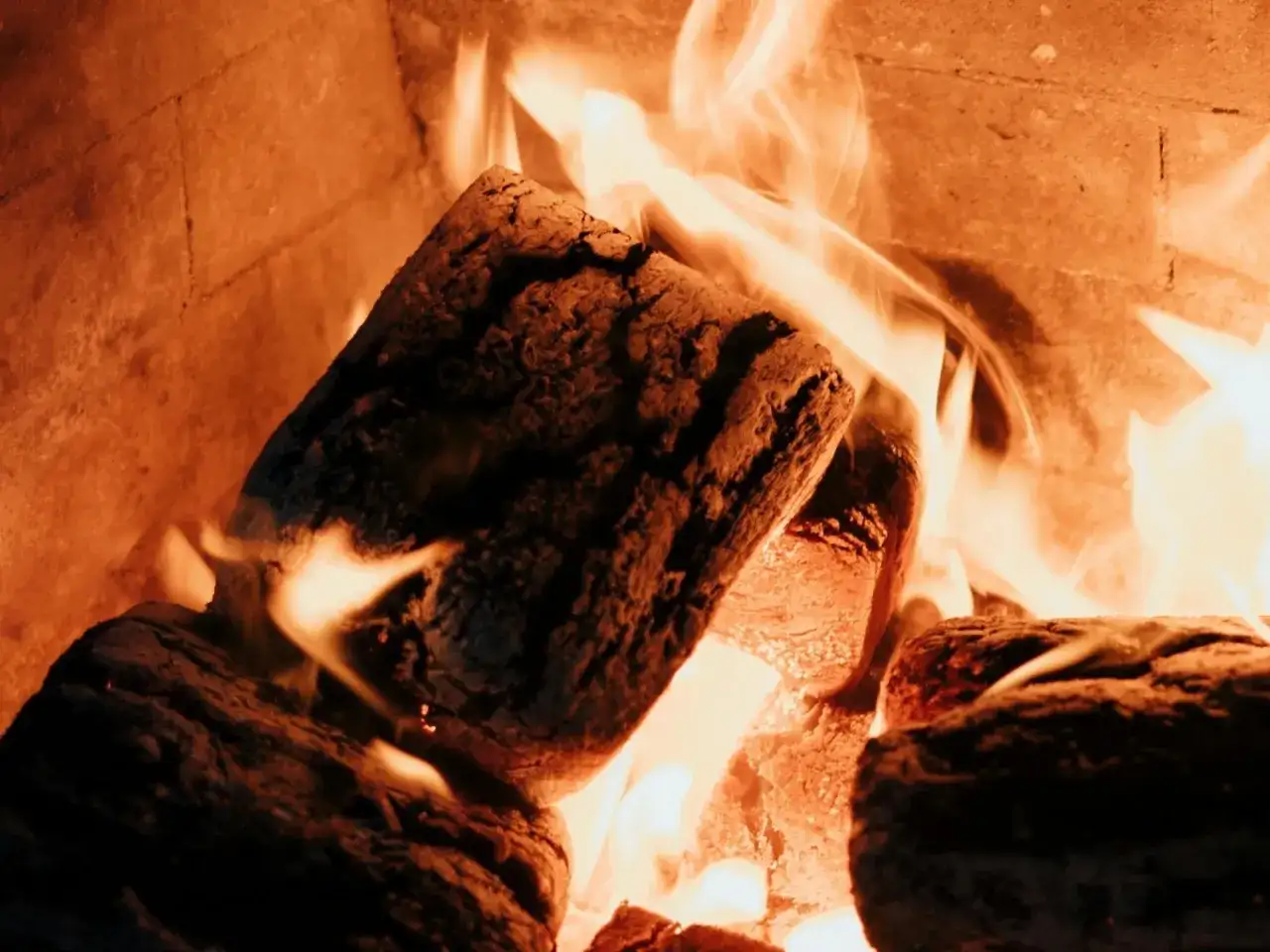 Legna che arde in un forno, un'immagine che evoca il calore e la semplicità di come pulire il forno a legna dopo l'uso.