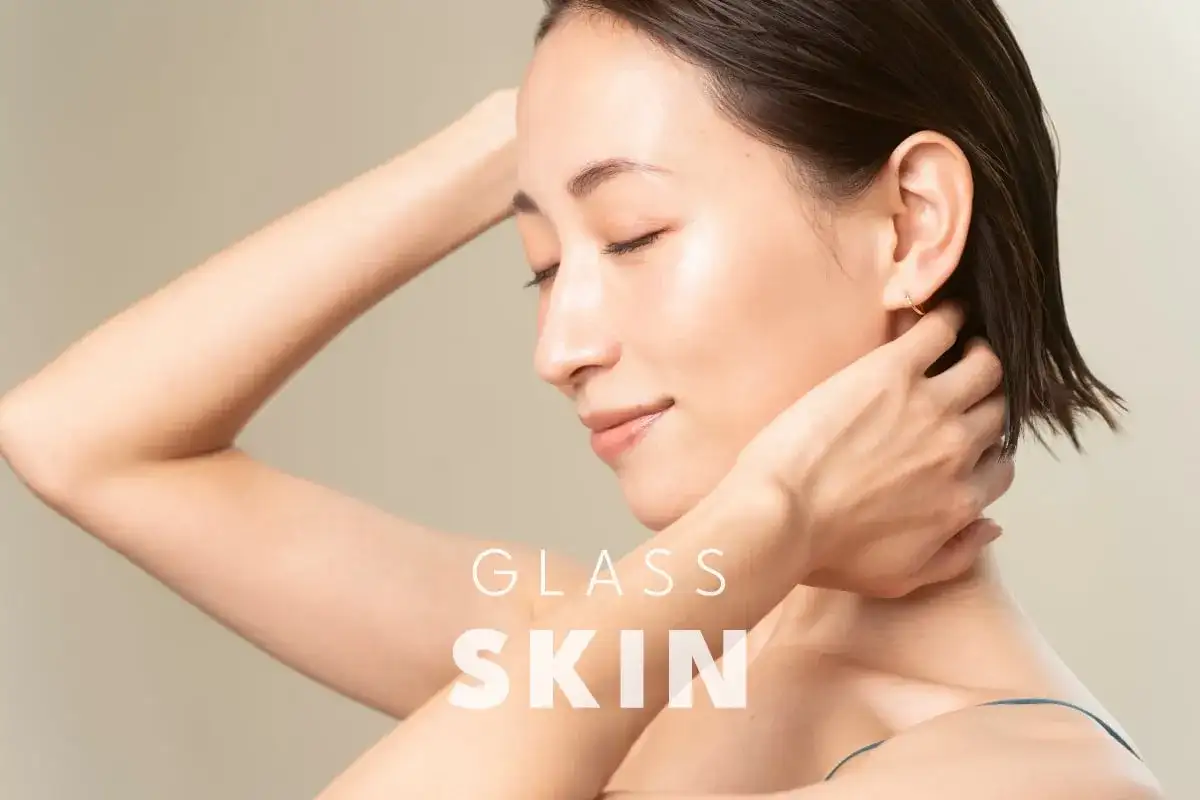 Kobieta z idealną, lśniącą cerą, która przypomina efekt glass skin. Jej skóra jest gładka i promienna.