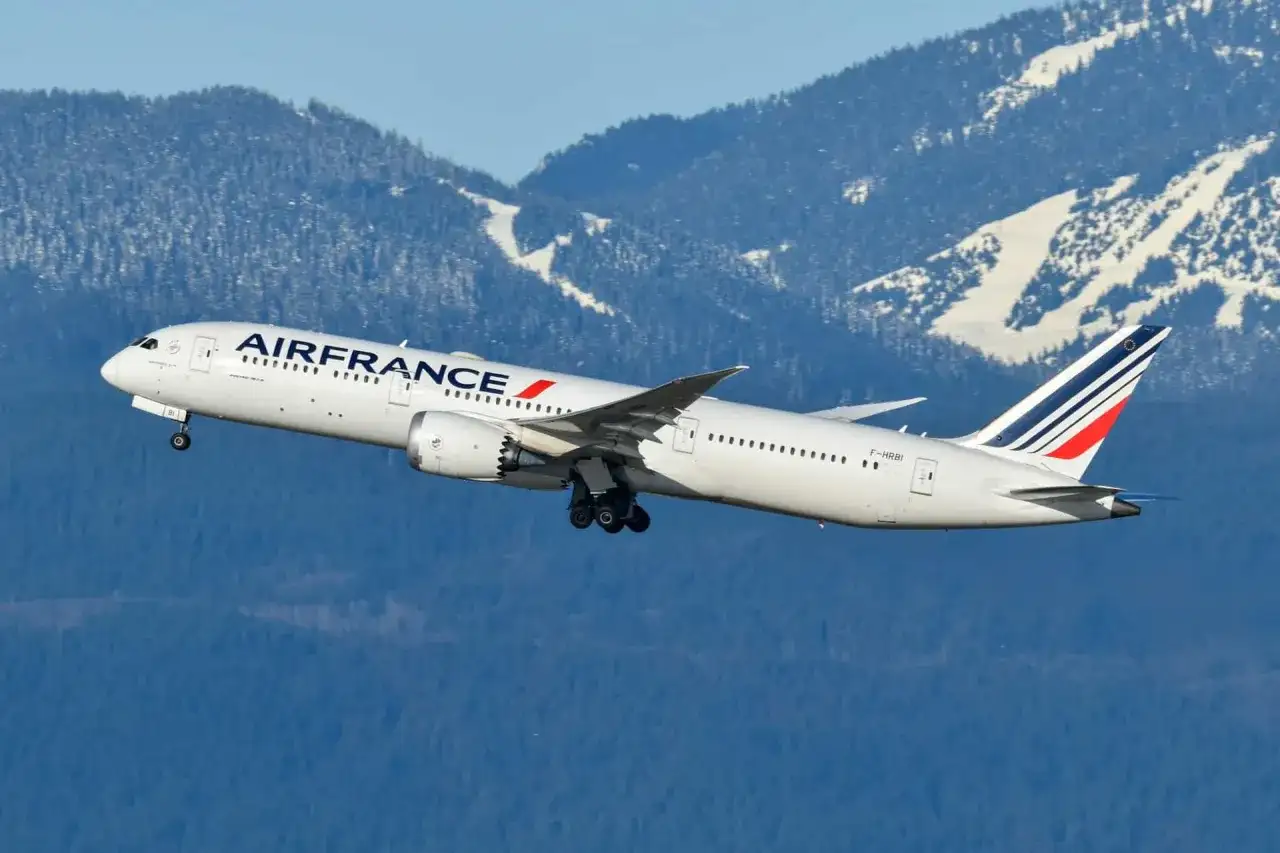 Samolot Air France wznosi się na tle ośnieżonych gór. W bagaż rejestrowany można spakować wszystko, co potrzebne na podróż.
