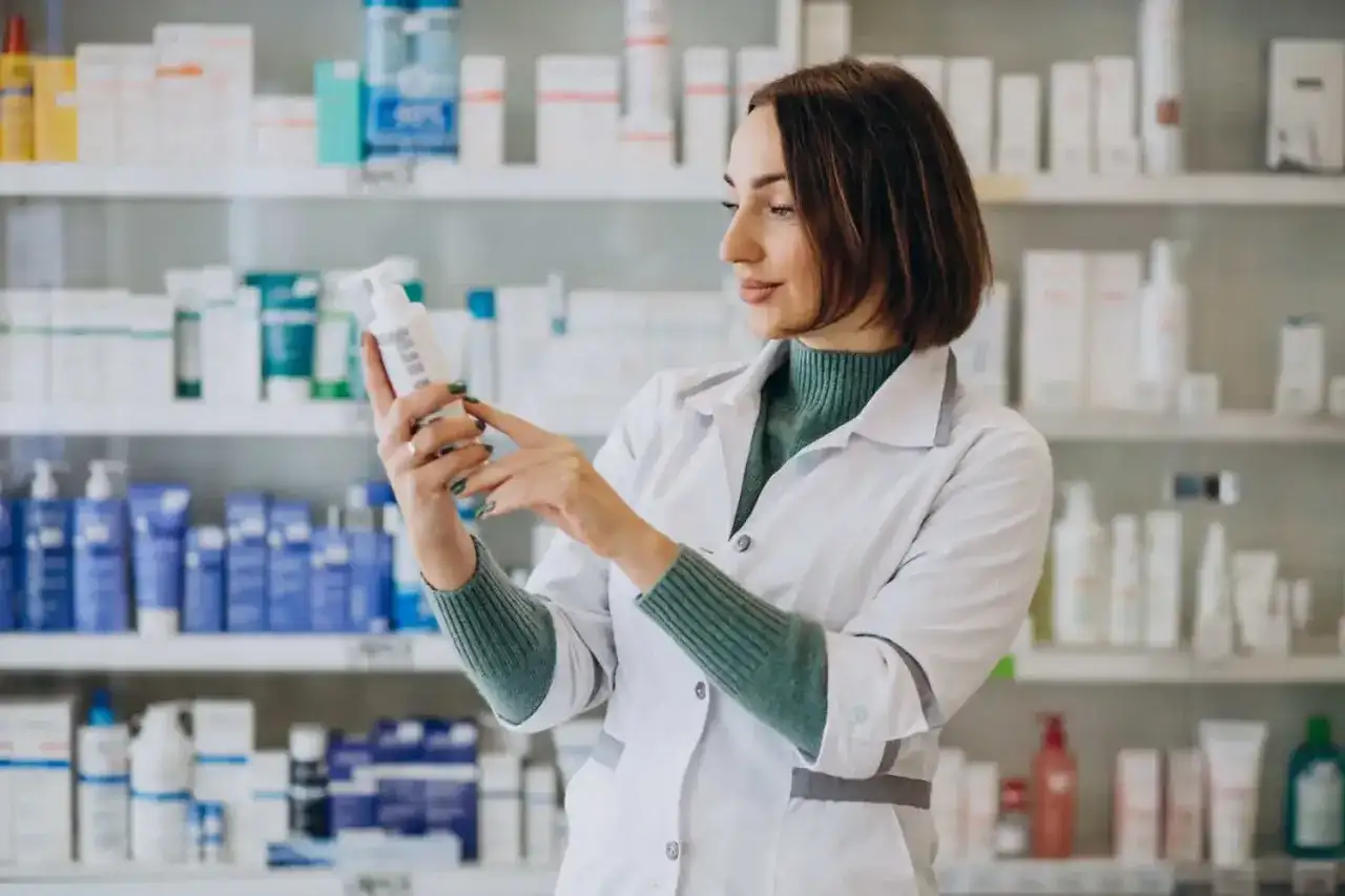 Farmaceutka w białym fartuchu analizuje skład leku, który może być wydany na receptę farmaceutyczną.