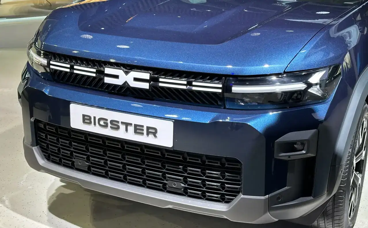 Niebieski Dacia Bigster z napisem "BIGSTER" i grillem z logo marki. Wyobraź sobie podróż tym autem na LPG!