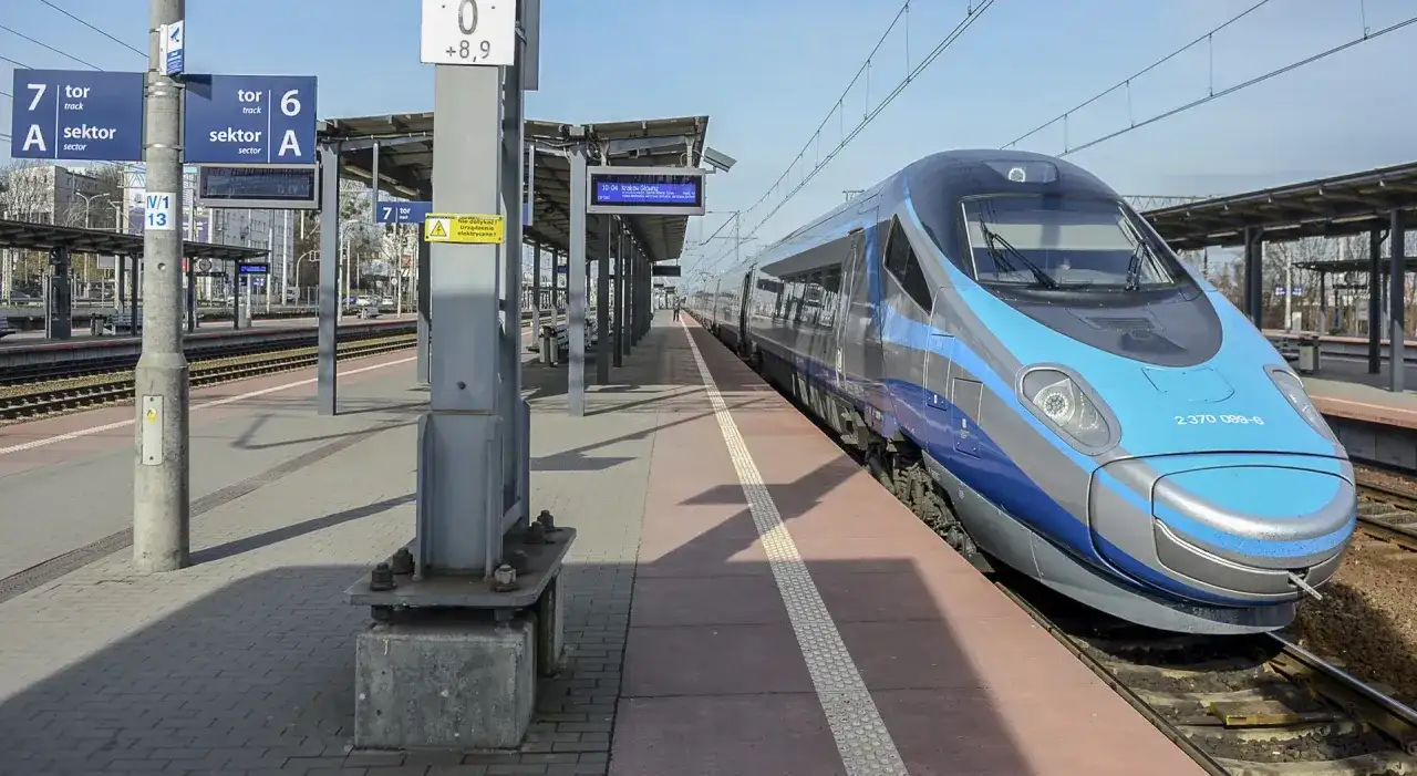 Pendolino na stacji, czy jedzie do Zakopanego? Pociąg stoi na peronie, w tle tablice informacyjne.