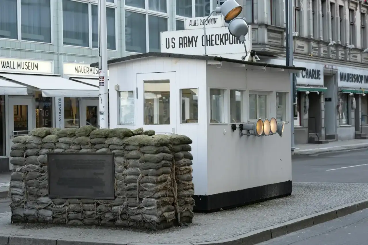 Checkpoint Charlie, dawne miejsce kontroli granicznej, z workami z piaskiem i tablicą pamiątkową.