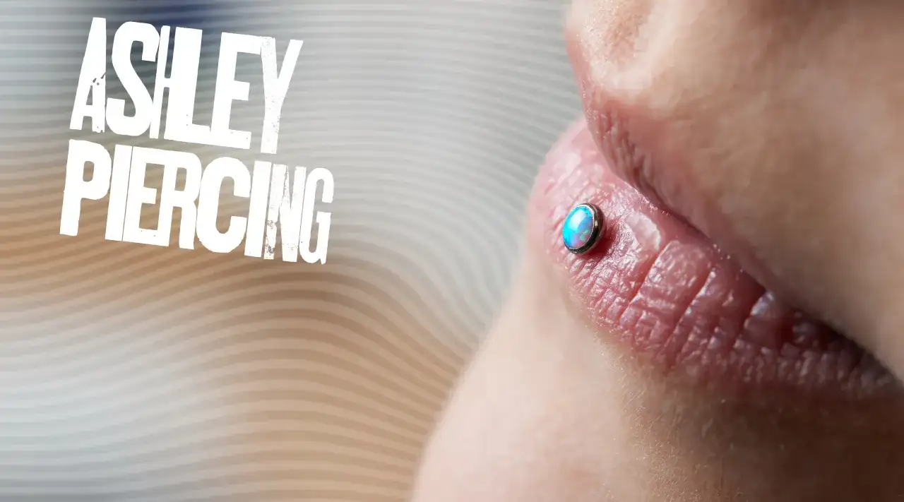 Ashley piercing na ustach z opalizującym kamieniem.