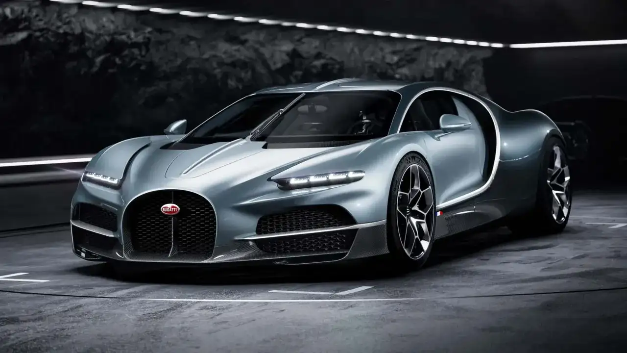 Srebrny Bugatti Tourbillon, symbol luksusu i mocy, prezentuje swoje aerodynamiczne linie w mrocznym wnętrzu.