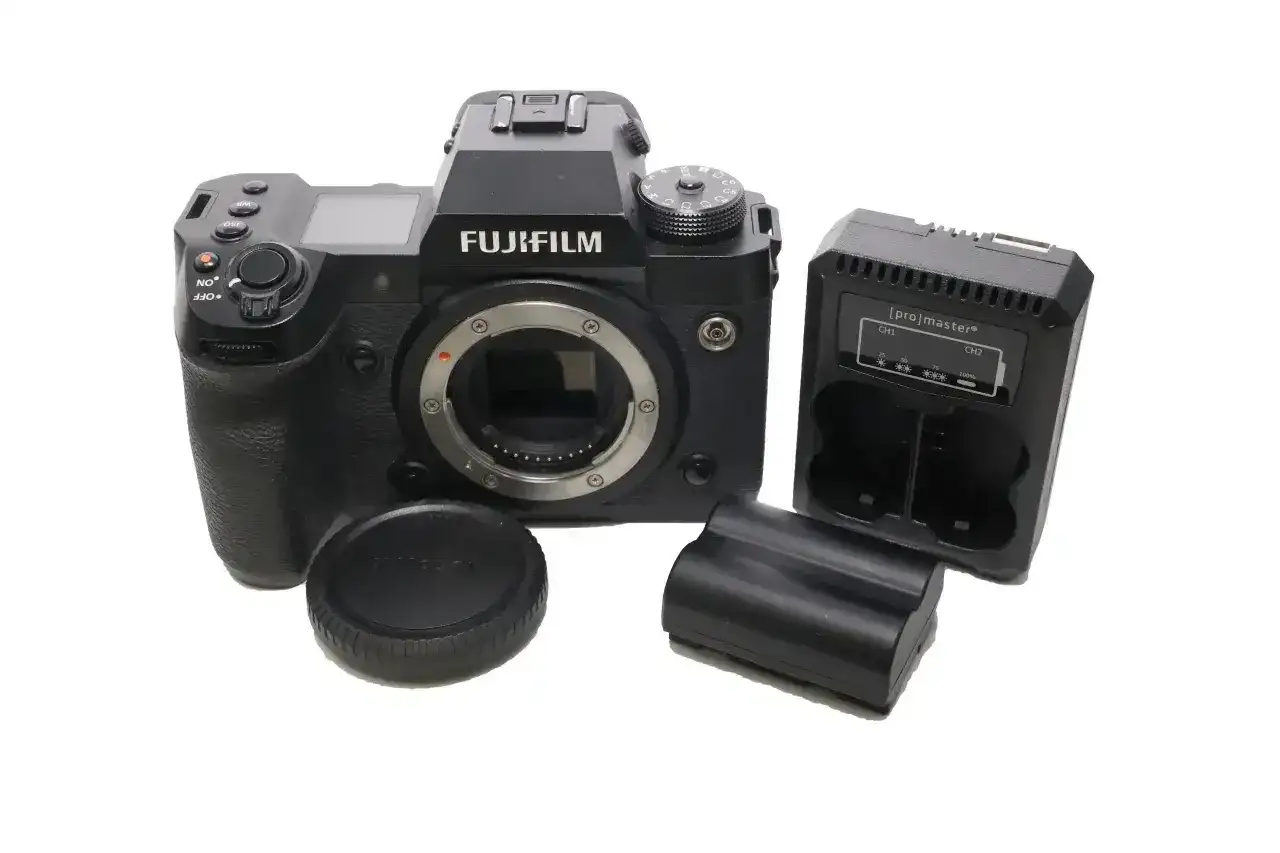 Aparat Fujifilm xh2s z obiektywem, ładowarką i bateriami.