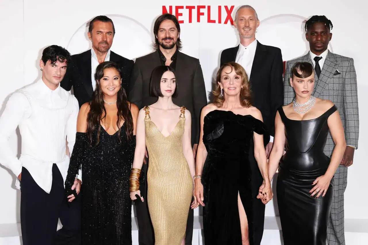 Cała obsada serialu "Emily w Paryżu" pozuje do zdjęcia na ściance Netflix.