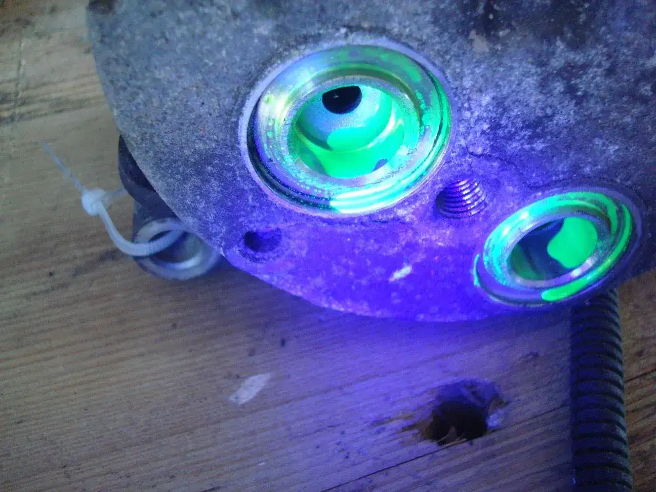 Détection de fuite climatisation voiture : le traceur fluorescent vert révèle une infiltration dans le compresseur.
