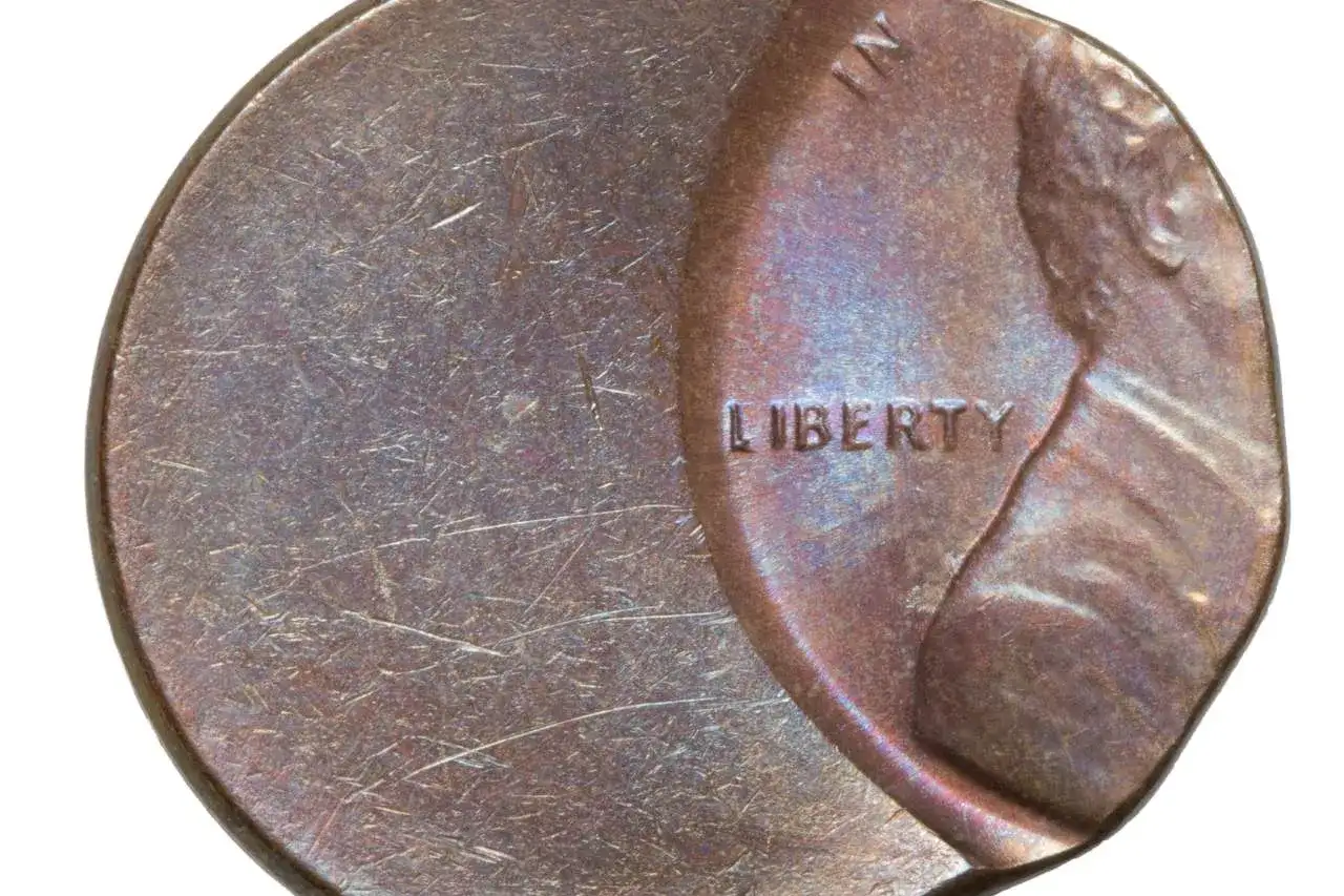 Zniszczona moneta z napisem "LIBERTY". Widać ślady użytkowania i drobne uszkodzenia.