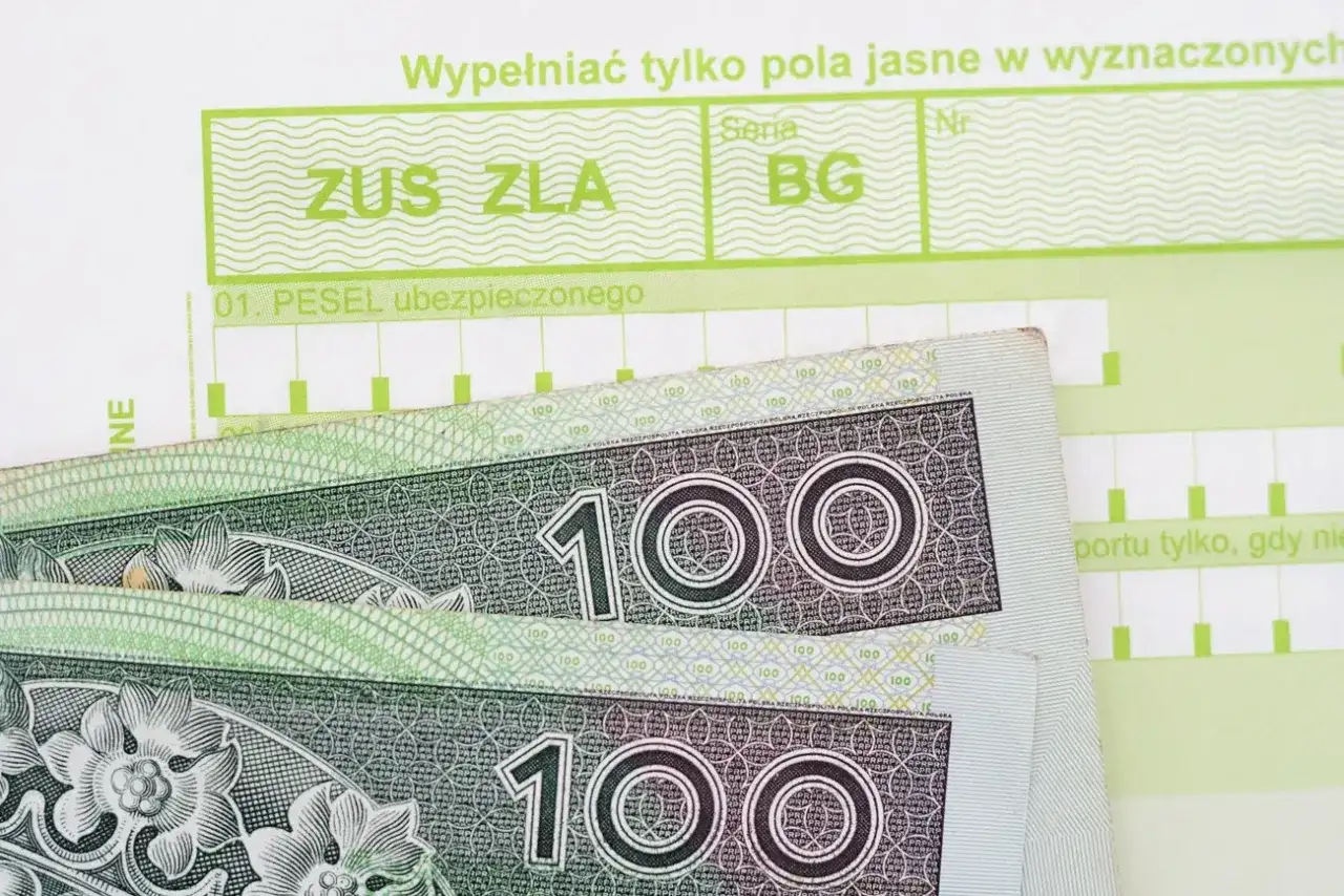 Formularz ZUS ZLA i banknoty 100 zł. Dokumentacja do wypłaty zasiłek chorobowy.