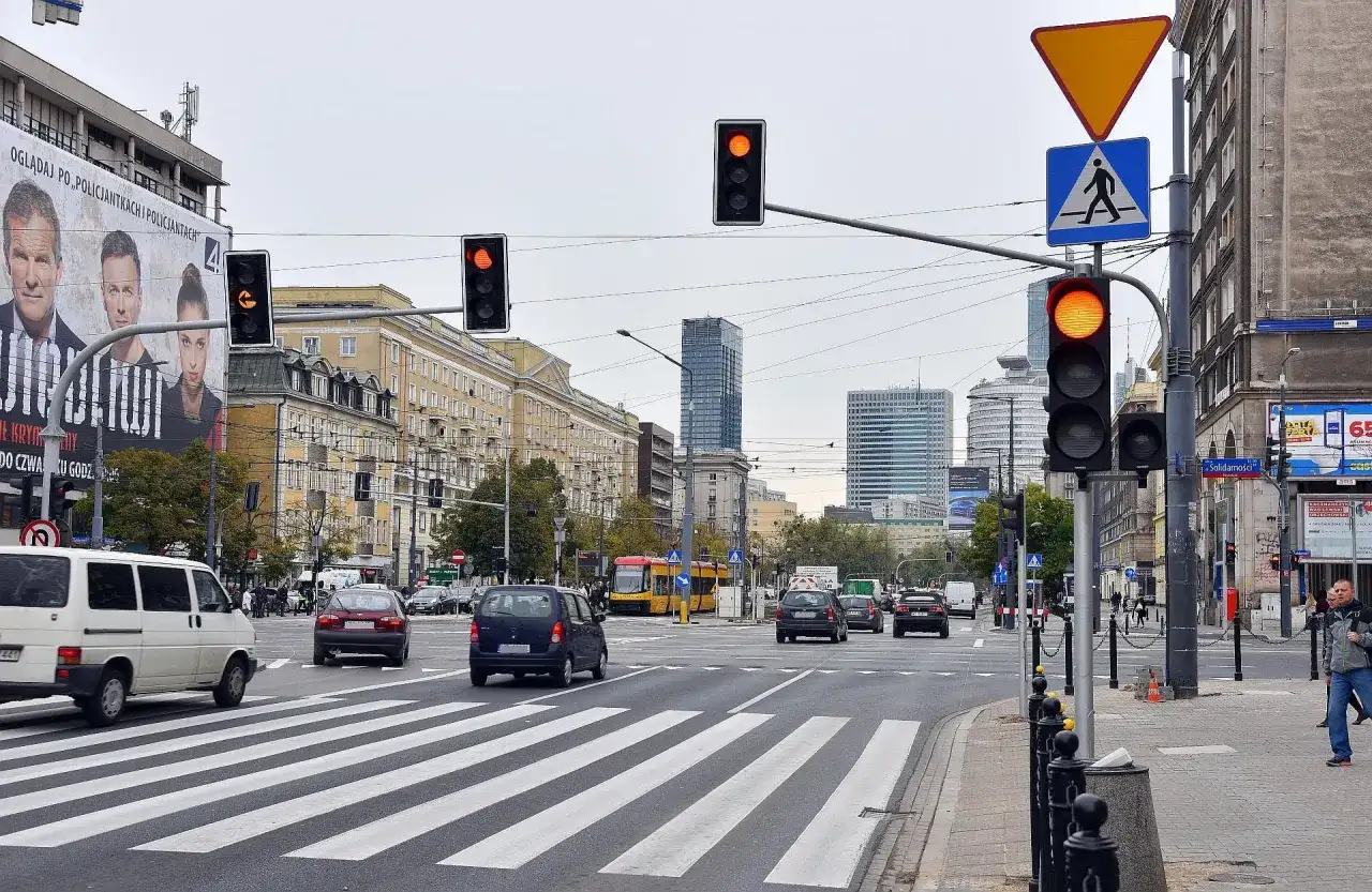 Skrzyżowanie z sygnalizacją świetlną, tramwajem i samochodami. Zastanawiasz się, po jakim czasie przychodzi mandat za przejazd na czerwonym świetle?