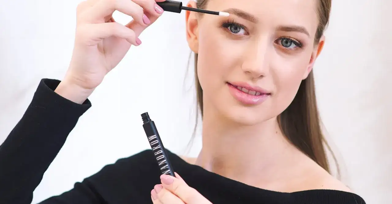 Kobieta aplikuje produkt do brwi Nanobrow, tworząc perfekcyjny makijaż.