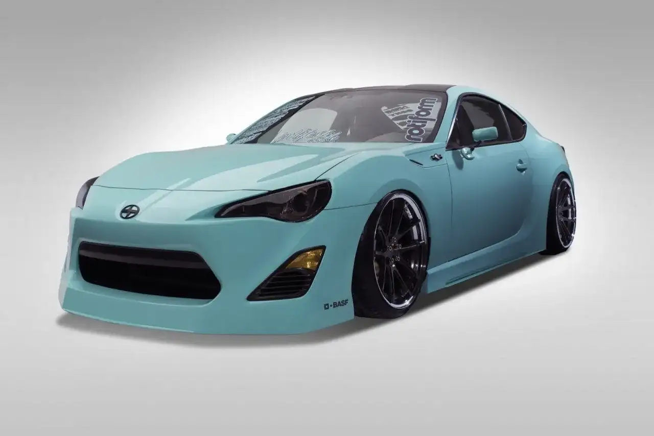 Turkusowy Scion FR-S z czarnymi felgami i przyciemnionymi światłami, gotowy do jazdy.