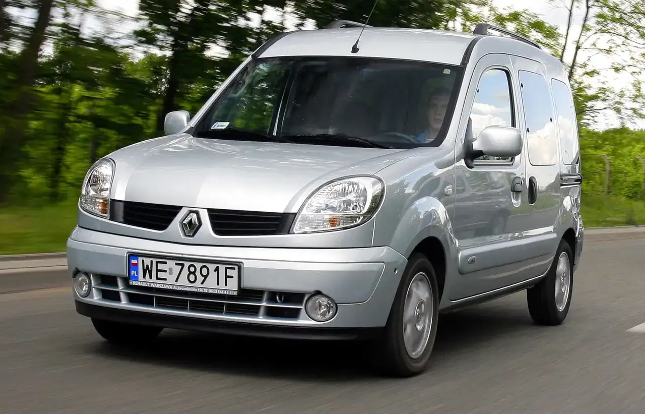Srebrny Renault Kangoo 1.5 dCi jedzie po drodze wśród zieleni.