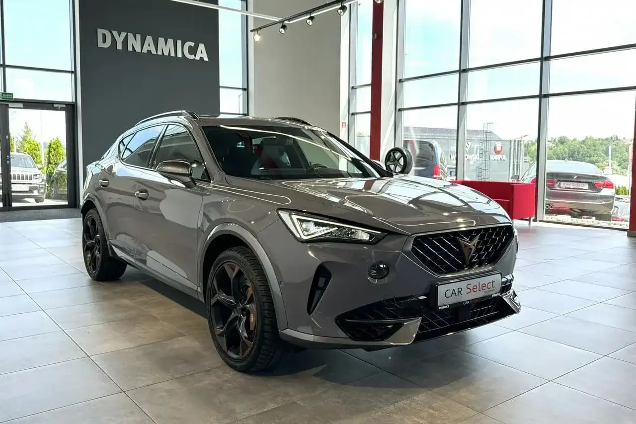 Szary Cupra samochod z czarnymi felgami stoi w salonie.