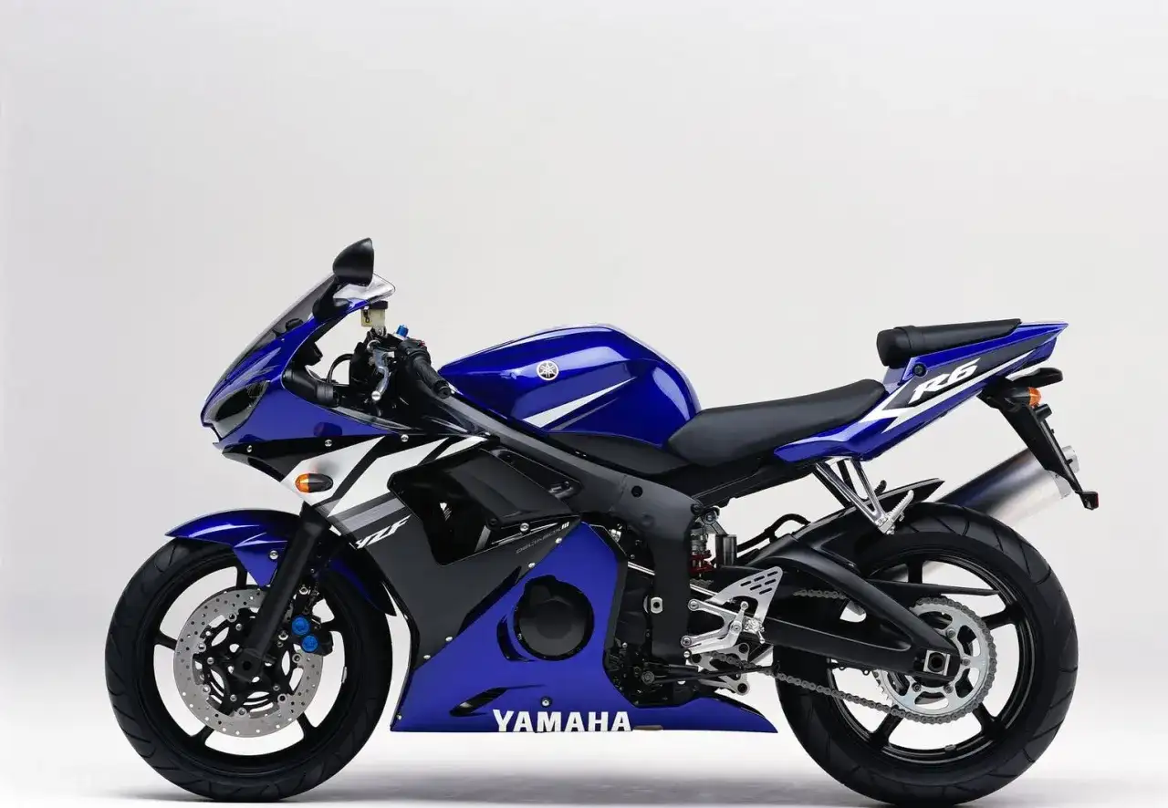 Niebieski motocykl sportowy Yamaha R6 2003 z białymi akcentami, gotowy do jazdy po torze.