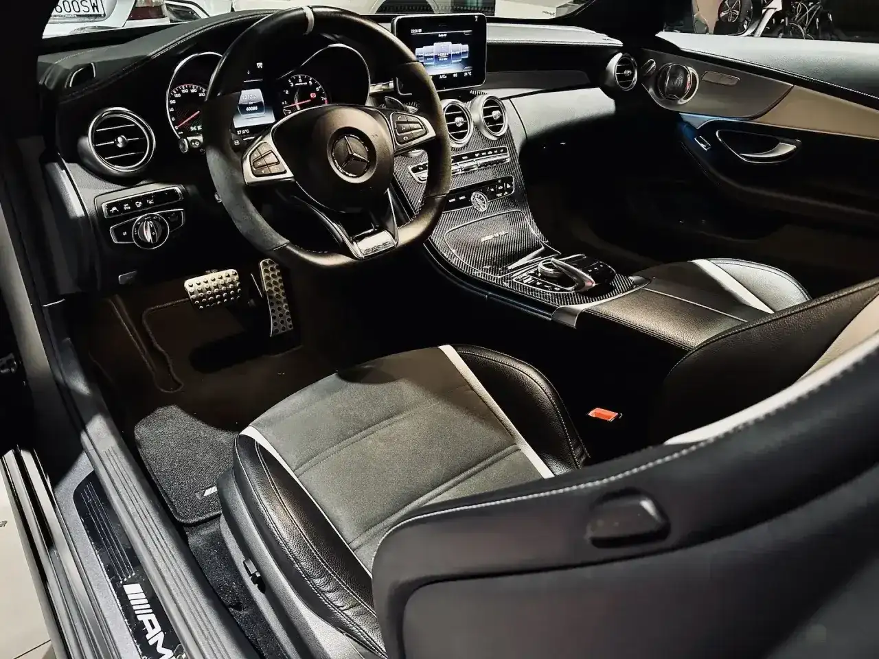 Wnętrze sportowego Mercedesa C63 AMG W204: skórzane fotele, karbonowe detale i sportowa kierownica.