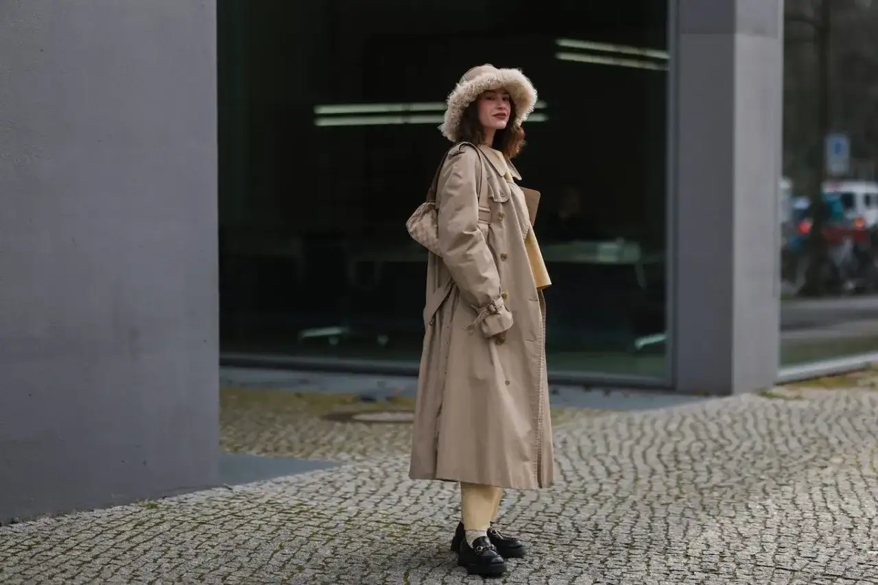 Eleganckie loafersy damskie dopełniają stylizację z beżowym płaszczem i futrzaną czapką.